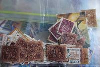 Close-up of one clear plastic bag containing brown used stamps and other stamps from Portugal