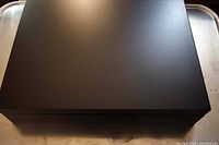 Closed black storage box for the cutlery set, with a smooth matte finish and slight surface marks visible.