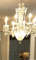 Close-up frontal view of lit chandelier showing crystal detail and candle lights
