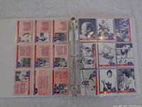 View of 18 hockey cards in plastic sleeves inside a ring binder, front and back sides visible showing black and white images, text and stats about players from the 1972 Canada vs Russia series.