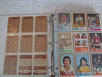Open binder showing two pages with 18 hockey cards on the right side in plastic sleeves and backs of cards on the left.