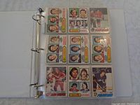 Front view of 9 hockey cards in binder sleeve, featuring player portraits and team logos such as Capitals, Blues, Canucks.