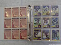 Open binder facing two pages; left page shows backs of nine cards with player stats, right page shows fronts of nine cards featuring Pittsburgh Penguins players.