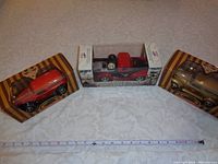 Three die cast collectible trucks in original packaging on a white surface, measuring about 7 inches each.