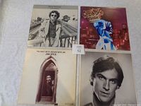 Four vinyl LP albums displayed on a flat surface, showing the cover art of Jim Croce, Randy Newman, and two Jethro Tull records.