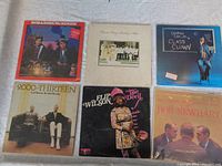 Front side of all six vinyl LP records arranged on a flat surface showing album covers by various comedians including Bob & Doug McKenzie, Carl Reiner & Mel Brooks, George Carlin, Flip Wilson, and Bob Newhart.