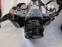 Front view of Canon AL1 camera with attached 50mm lens and Canon strap