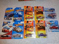 Photo showing front view of all ten die cast vehicles in original unopened packaging including Hot Wheels, Matchbox, Maisto, and others.