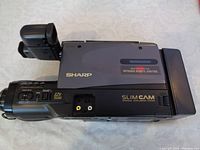 Side view of Sharp SlimCam VHS camcorder showing optical zoom 12x and infrared remote control sensor