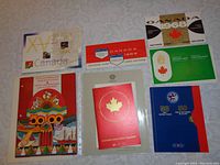 Image showing various Canadian souvenir stamp cards and booklets including a 1994 booklet, 1964, 1968, 1970, 1972 souvenir cards and a 1975 souvenir collection booklet with colorful covers.