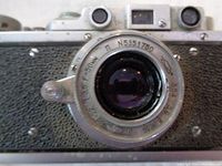 Front close-up of vintage Zorkiy camera lens showing serial number and aperture markings.