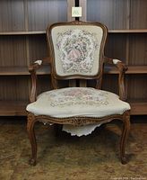 Front view of wooden chair with ornate Victorian style cushioning and carved details.