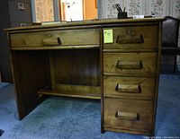Wood desk angled view showing drawer configuration and panel sides.