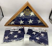 Veterans of Foreign Wars triangular flag case with folded U.S. flag inside, with two new 3x5 US flags in front still in packaging.