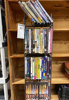Photo showing multiple DVDs in rack including movie titles and cover art.