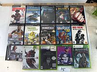 Full layout showing all 15 game cases for PlayStation 2, Xbox, and Xbox 360 laid out side by side on a surface.