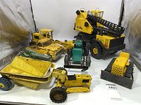 Full view of all vintage Tonka trucks and toy tractors with visible rust and paint wear.