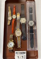 Photo of tray holding six assorted wristwatches of various styles and bands.