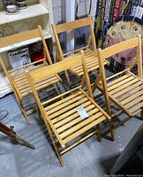 Set of 4 wooden folding chairs with slatted designs, viewed from above showing condition and arrangement.