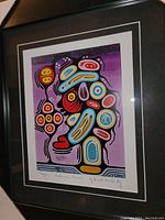 Close-up photo showing the colorful abstract print titled 'Medicine Flower' by Brent Hardisty with signature and edition marks visible, matted and framed in black.