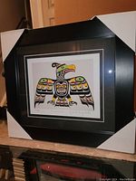 Front view of the professionally framed Thunderbird art print by Chief Mungo Martin with protective corner covers on the frame.