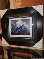 Photo of the professionally framed fine art print showing the artwork 'Mountain Forms' by Lawren Harris with protective corners on frame edges.