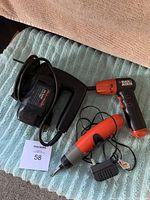 Full set of Black & Decker power tools - jig saw, rechargeable screwdriver with charger, and battery operated screwdriver on a textured fabric surface