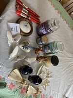 All items spread on a table including candles, butterflies, bunnies, angels, vases, and taper candles