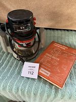 Photo of Craftsman 5/8 Hp Router on a textured surface alongside the orange router instruction manual and a MaxSold lot card.