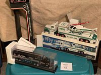 Overall view showing all three die-cast collectible trucks with their packaging and display cases