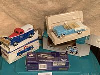 Three die-cast collectible vehicle banks displayed together showing overall lot content and packaging condition.