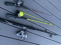 Three fishing rod and reel combos laid out showing rod colors and reel types.