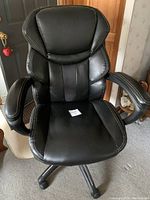 Front view of the Wellness by Design black office chair showing padded seat and backrest with armrests.