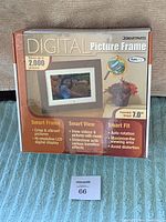 Box of SmartParts digital picture frame showing front with picture display and feature highlights