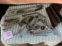 Overview of assortment of ratchet wrenches, breaker bars, extensions and accessories placed on a cloth surface.