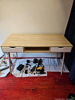 Front view of the office desk showing two drawers and open center compartment, with various items placed underneath.