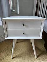 Front view showing overall form, two drawers, knobs and legs