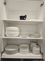 Three-tier cabinet view showing stacks of bowls and plates