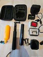 Photo showing assorted GoPro and Smatree accessories arranged on a white background including cases, mounts, handles, and tripod.