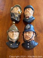 Top-down view of all four Bossons head vases on wooden surface