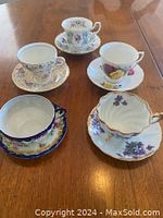 Top view of all five tea cups and saucers arranged in a circle