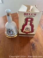 Full view of the commemorative ceramic bottle and original box on wooden table