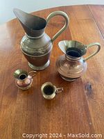 Top view of the four jugs showing relative sizes and metal finish.