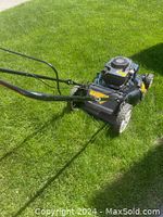 Side view of Craftsman 21-inch mulcher mower on grass showing rear grass collection bag and side discharge chute.