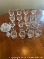 Wide view of entire mixed crystal lot showing multiple glasses arranged by pattern along with butter dish with lid and other items