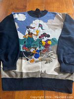 Front of sweater showing full Disney golf character scene with Mickey, Donald, and Goofy.