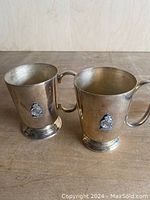 Two silver plated tankards, side by side, showing overall appearance and height.