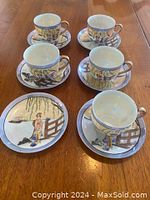 Full view of four hand painted Japanese Geisha girl cups and saucers, one saucer extra, arranged on wood table showing colorful detailed scenes.