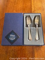 Top view of original blue box containing two pastry forks with foam insert.