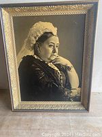 Full view of framed portrait of Queen Victoria with ornate frame and neutral background.
